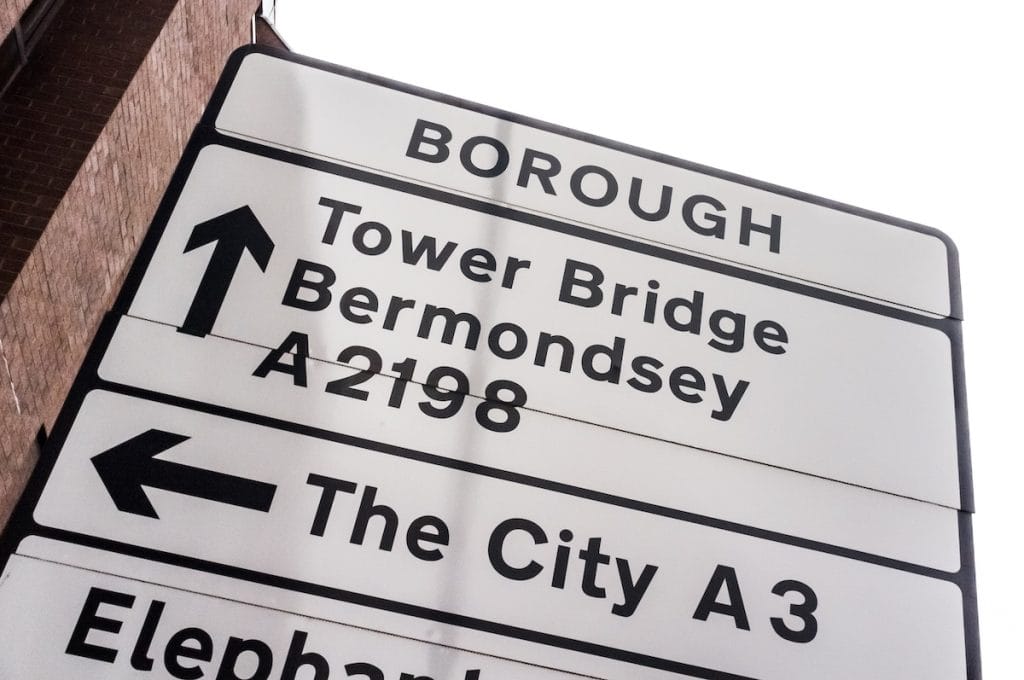 A street sign pointing to a building with a sign that says borough